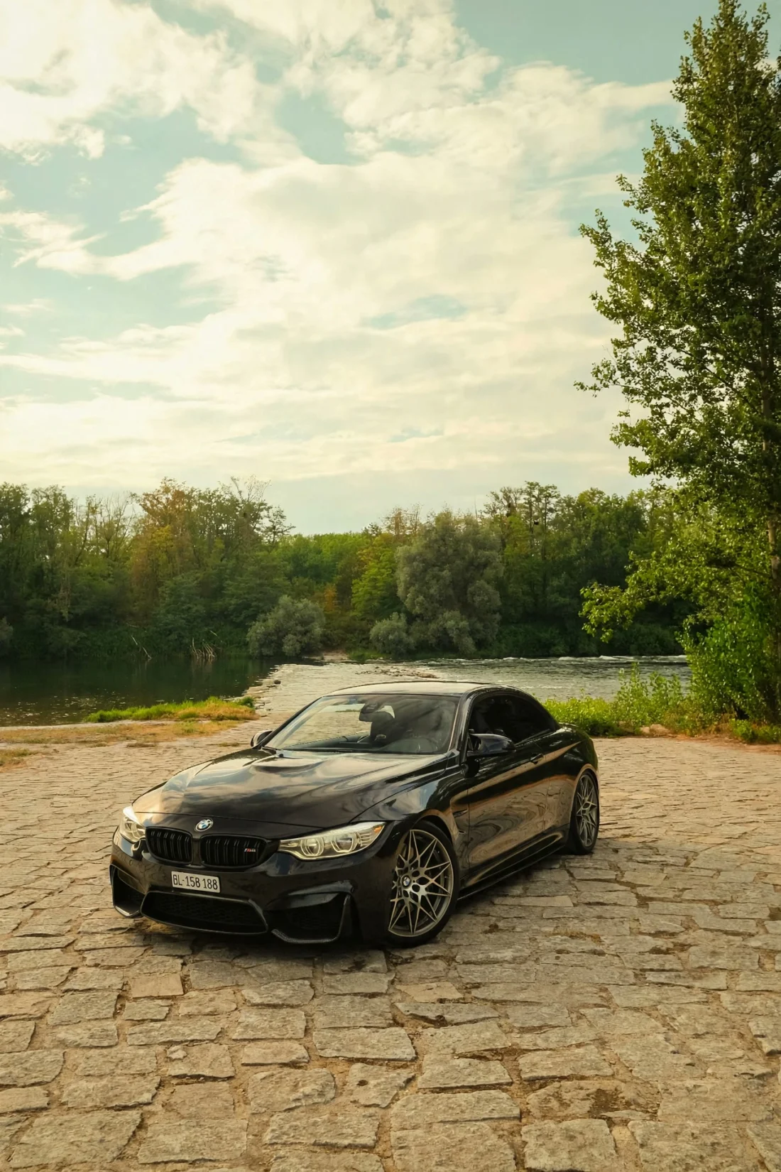 Black M4 front three-quarter by the river